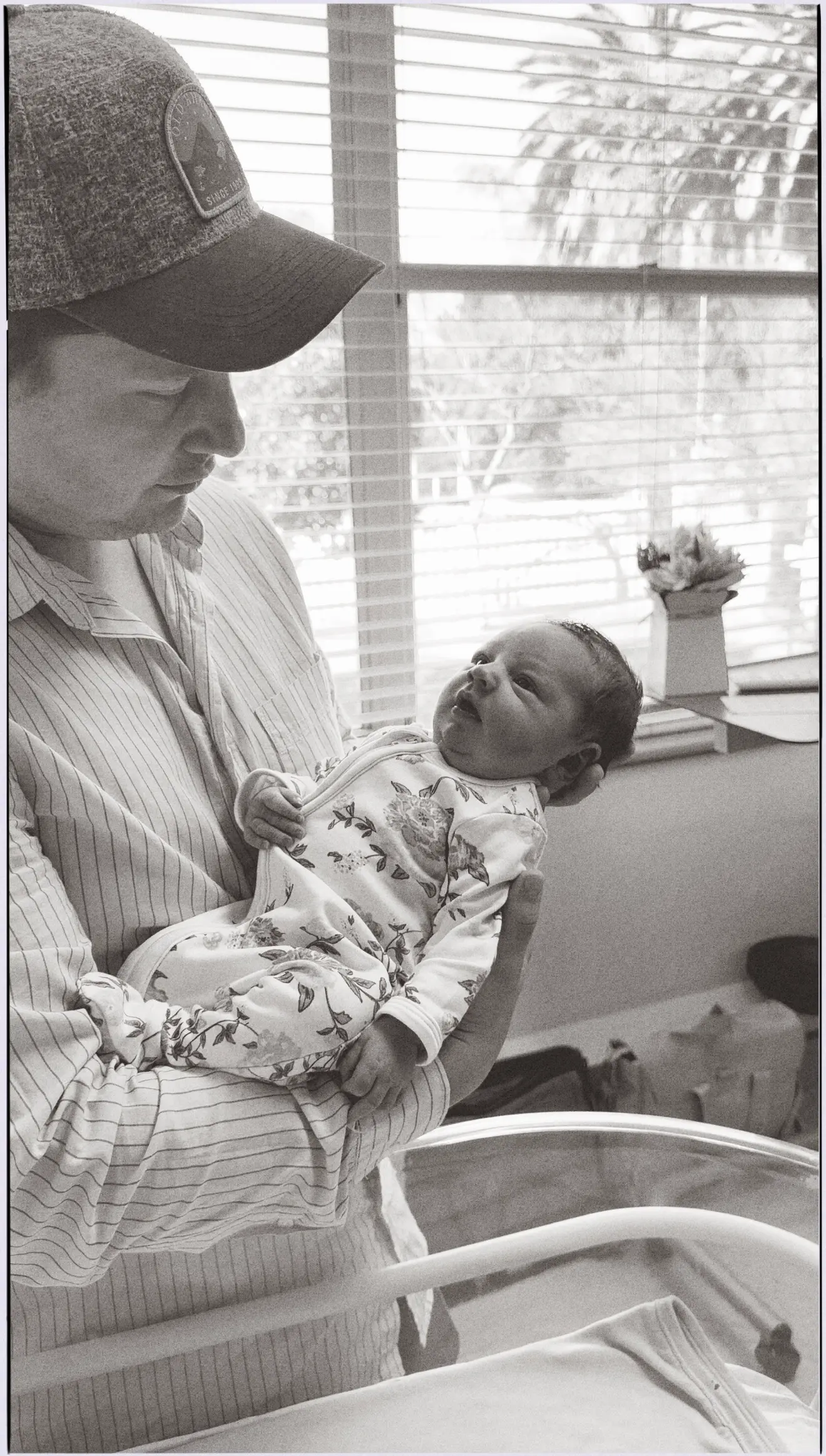 A black and white photo of a parent holding a newborn