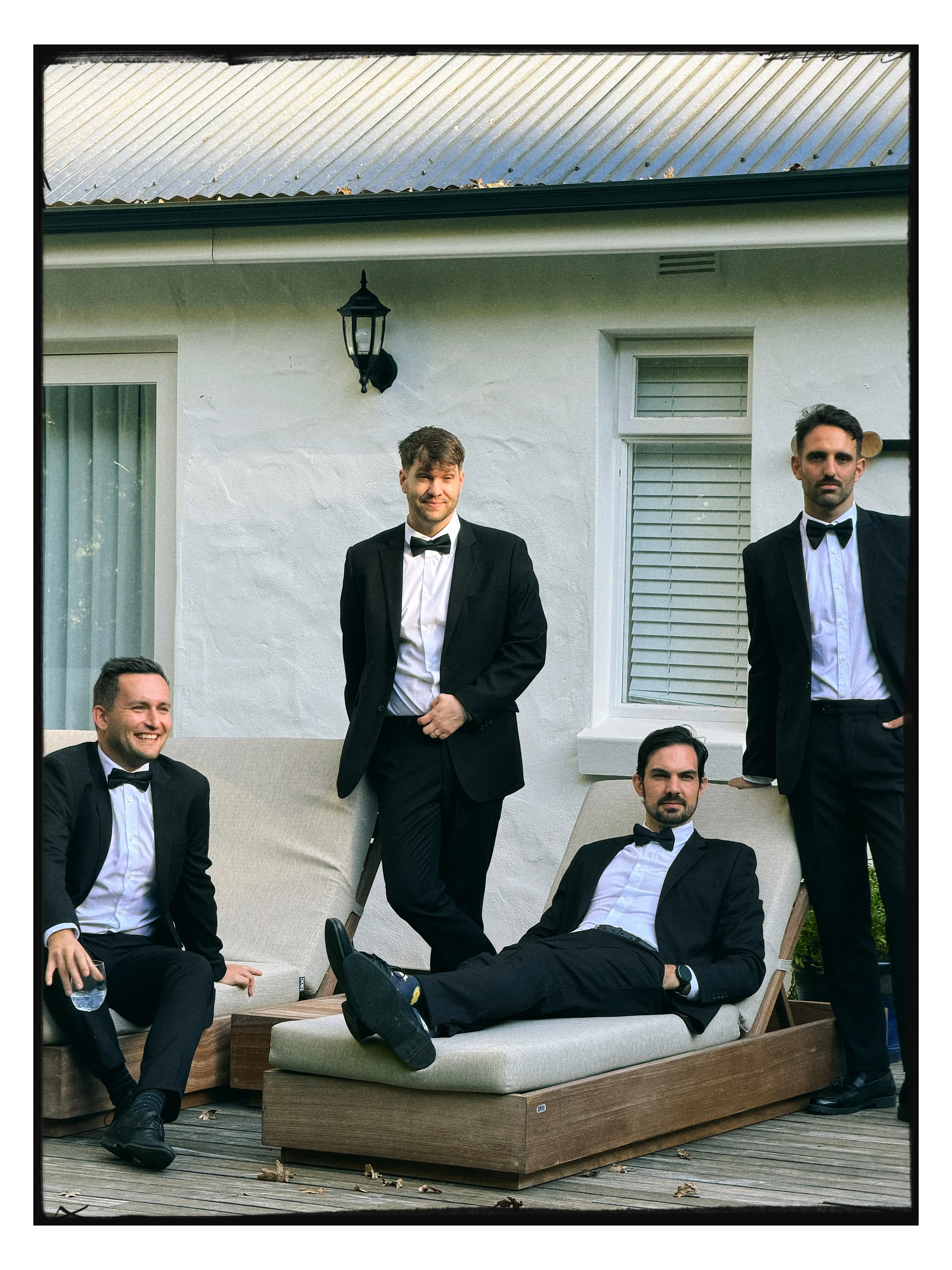 The groomsmen relaxing outside the house