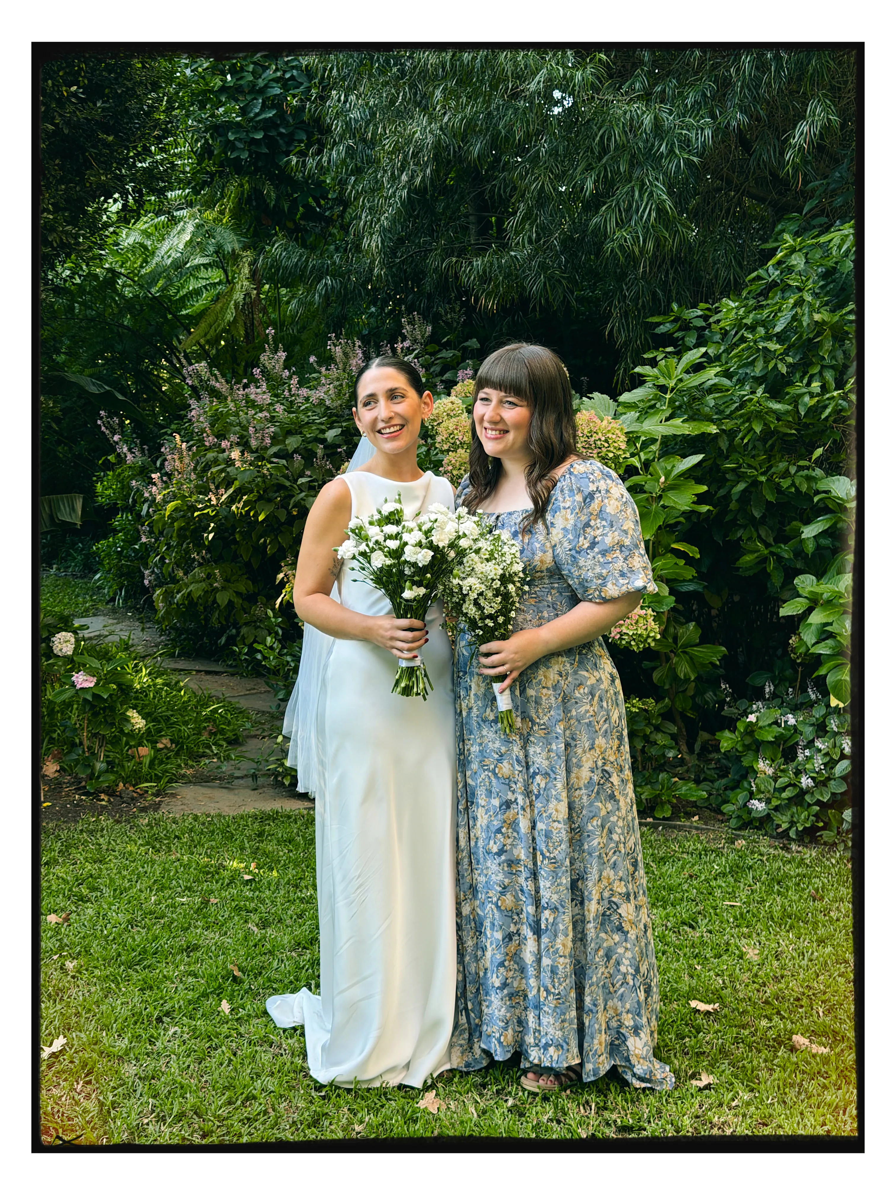 A bride and her bridesmaid in a garden