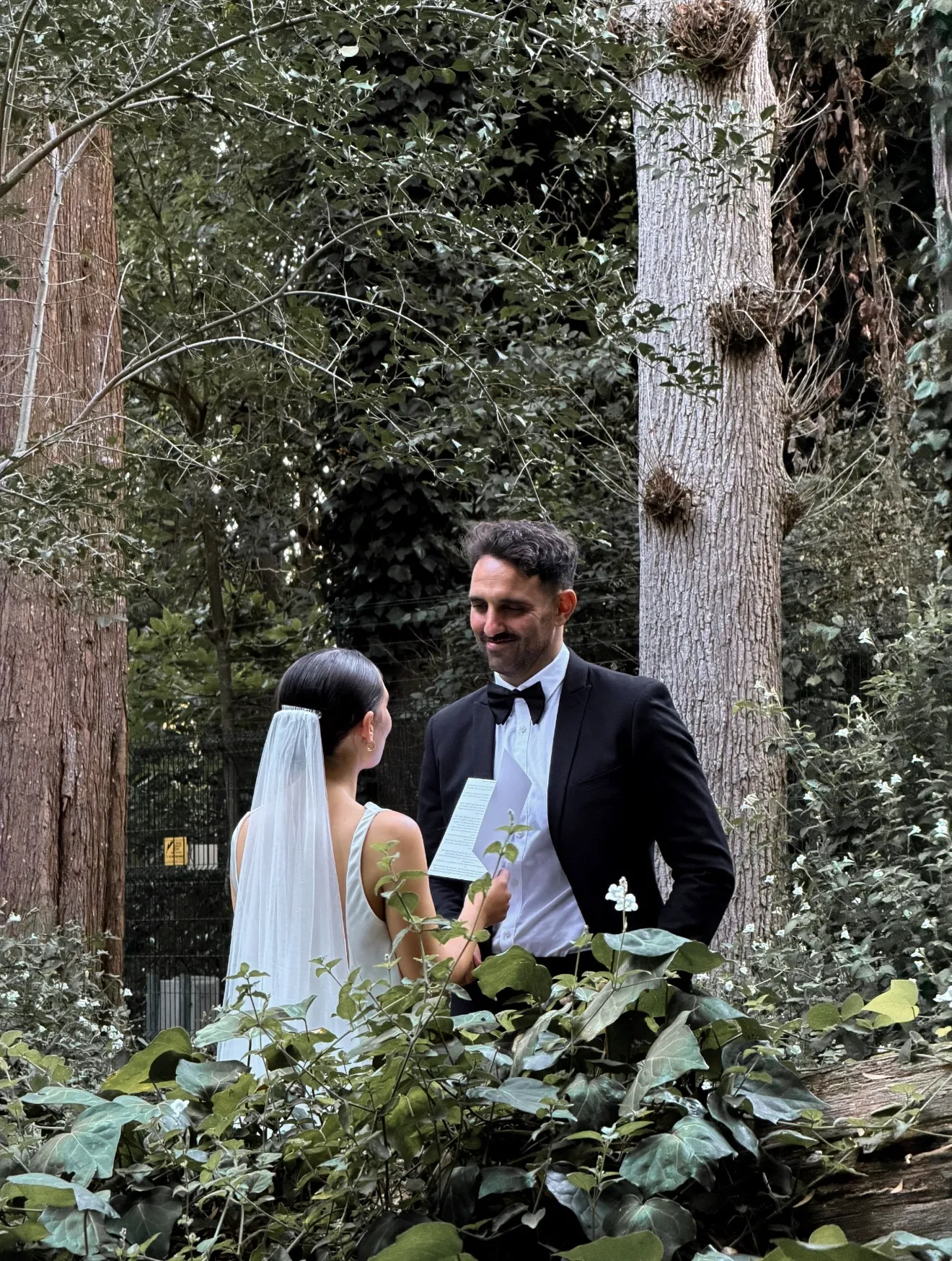A bride and groom in a leafy garden